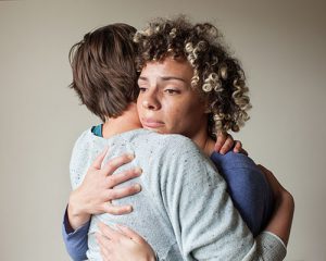 Photograph of women hugging each other supportively